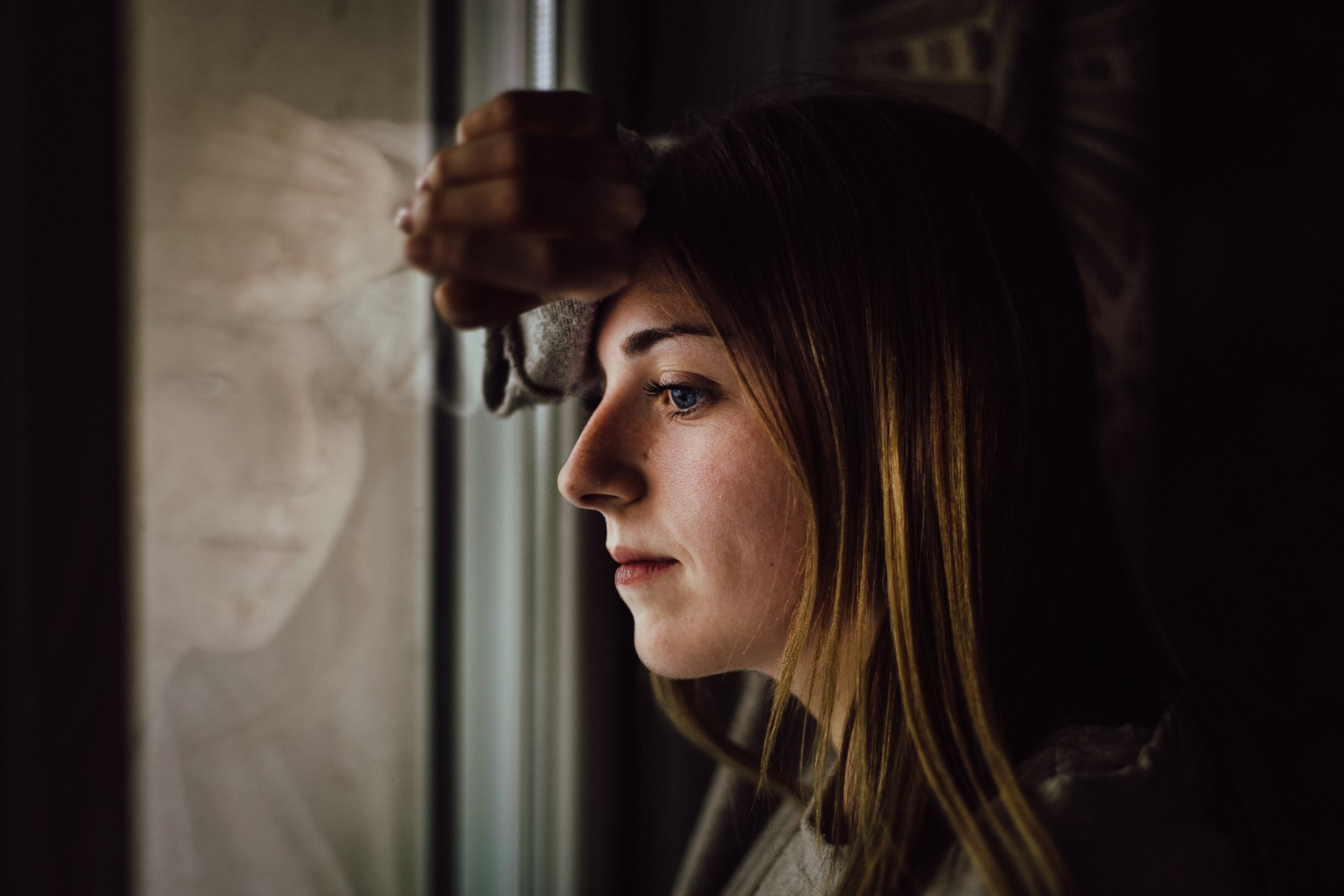 woman-leaning-on-glass-window-1101726 woman-leaning-on-glass-window-1101726